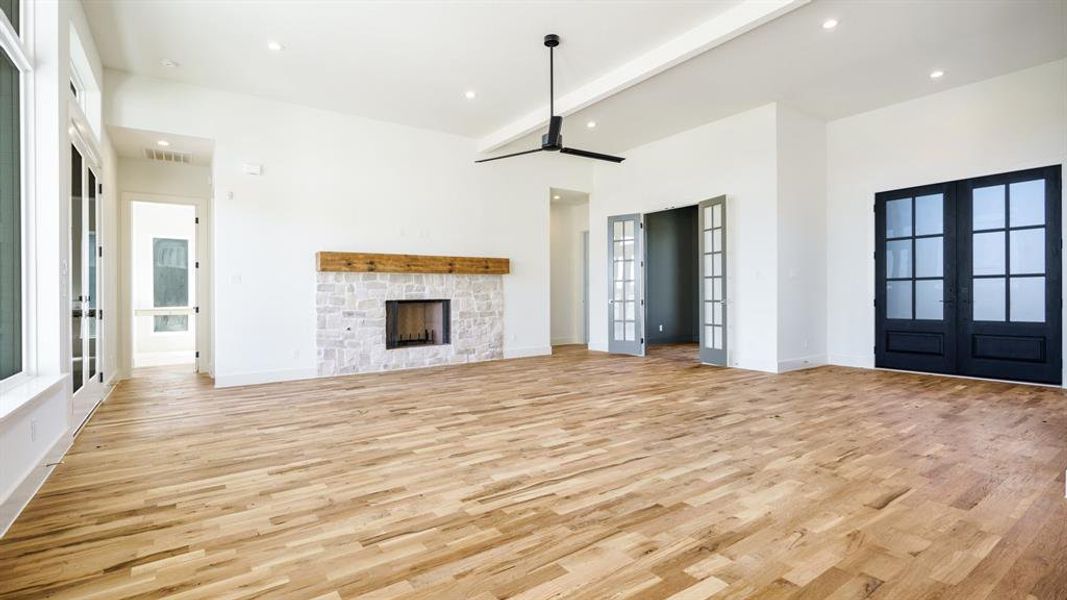 Unfurnished living room with light hardwood / wood-style flooring, french doors, and a healthy amount of sunlight