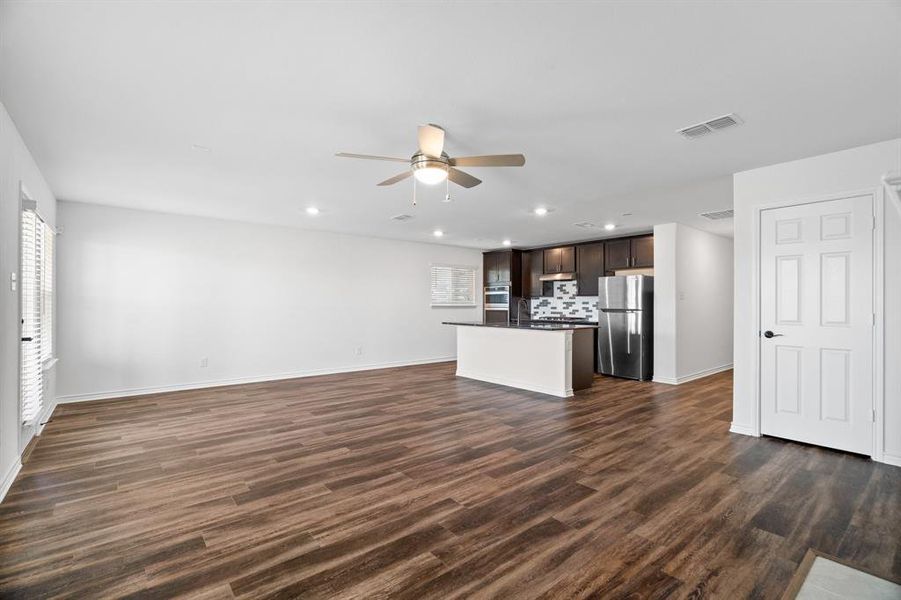 Unfurnished living room with dark hardwood / wood-style flooring and ceiling fan