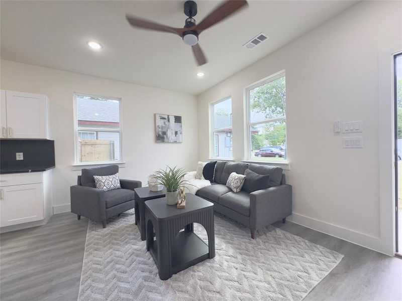 Living room with ceiling fan and light hardwood / wood-style floors