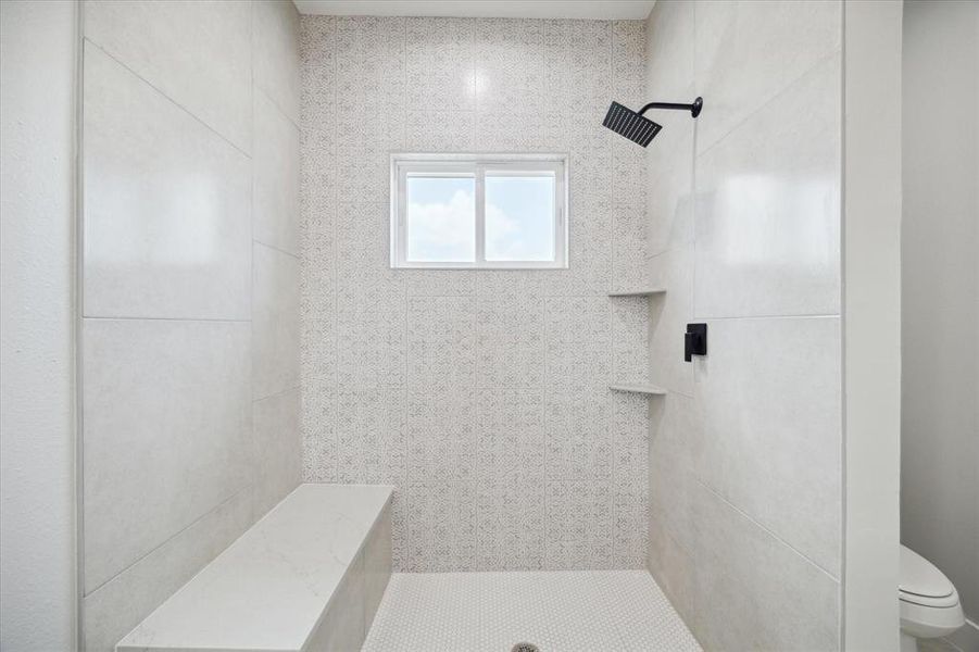 The primary bathroom shower includes a rain fall shower head