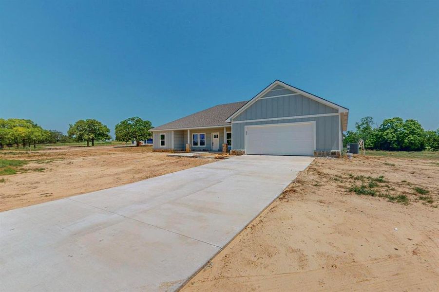 View of front of home with central AC and a garage