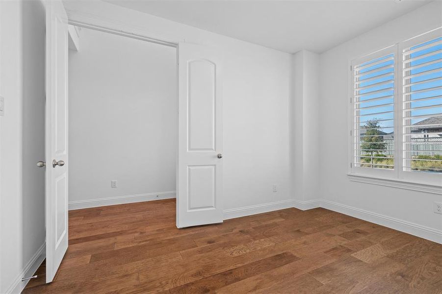 Unfurnished bedroom with dark wood-type flooring