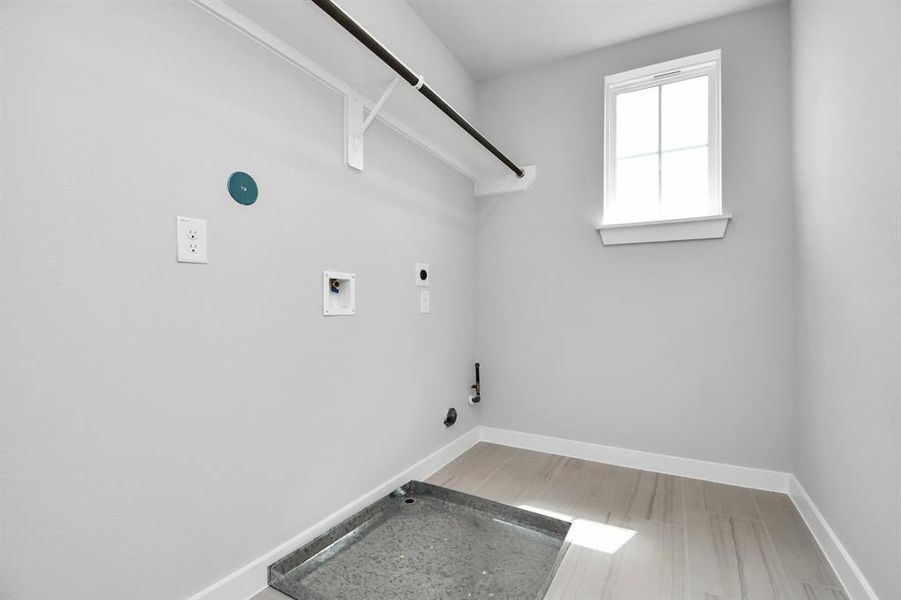 Stylish laundry room where practicality meets a contemporary aesthetic. The dark finishes lend a sophisticated touch, creating a space that is both functional and visually appealing. Both electric and gas connections available.