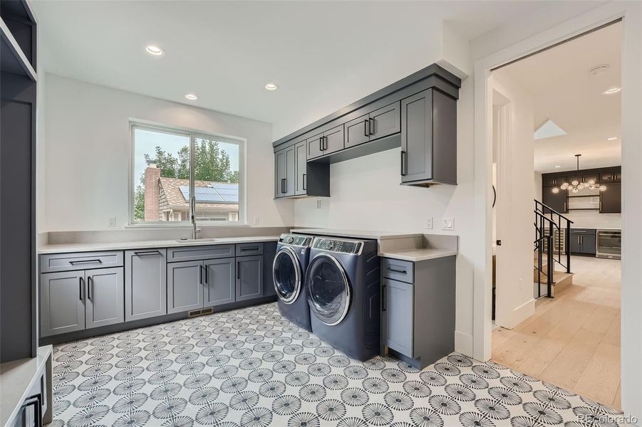 Large mud-laundry room on main level with storage and utility sink.