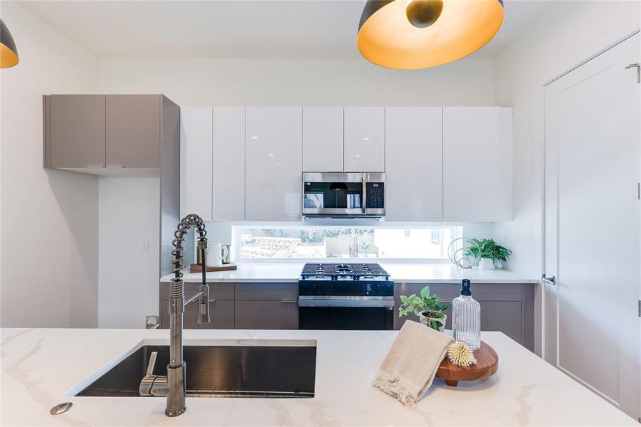 Kitchen featuring white cabinets, appliances with stainless steel finishes, and sink