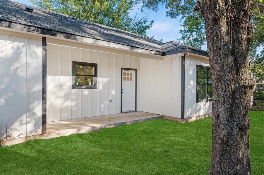 Property entrance featuring a patio and a yard