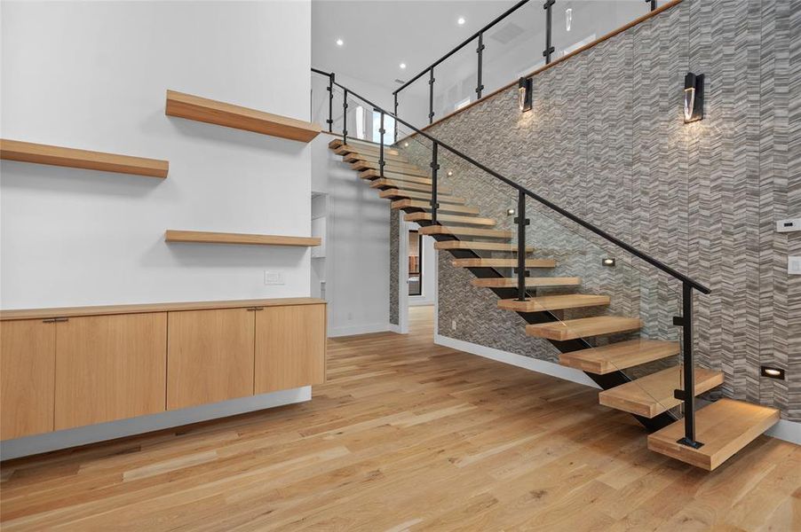 Stairs with a towering ceiling and hardwood / wood-style flooring