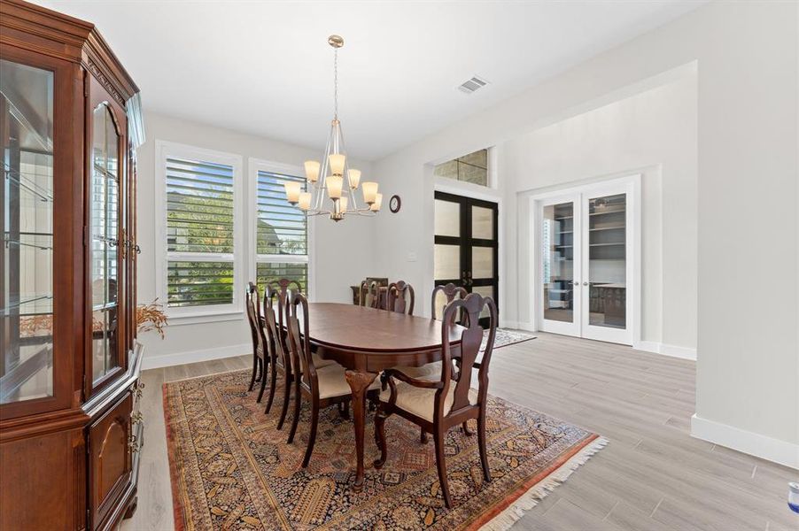 The dining area exudes elegance with its modern chandelier, creating a warm, inviting ambiance for gatherings.