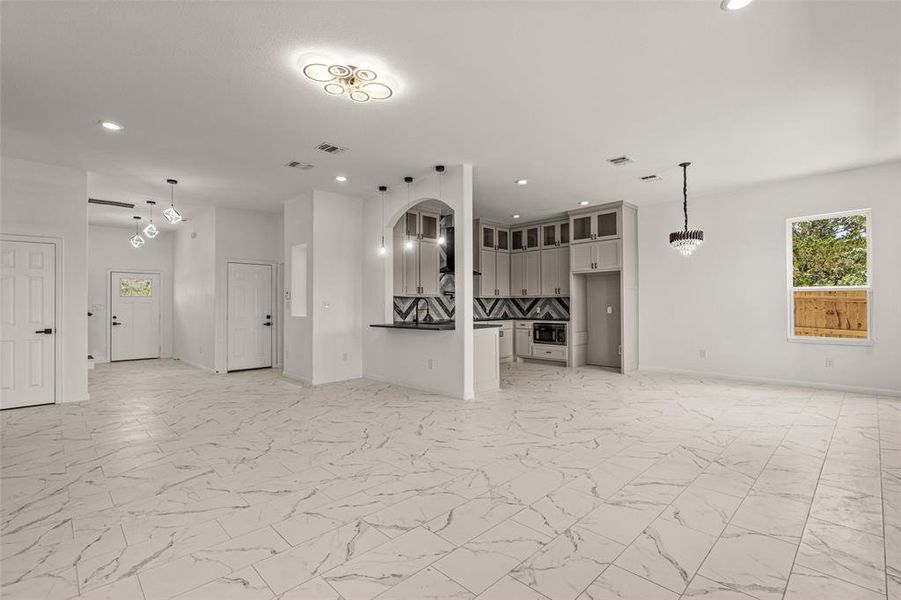 Unfurnished living room featuring light tile floors