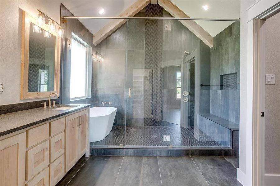 Bathroom featuring tile walls, lofted ceiling, separate shower and tub, and vanity