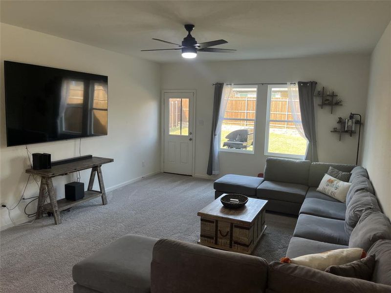 Living room featuring ceiling fan and carpet flooring