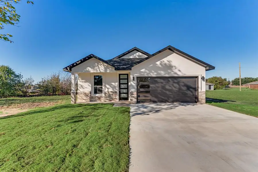 View of front facade with a front yard and a garage