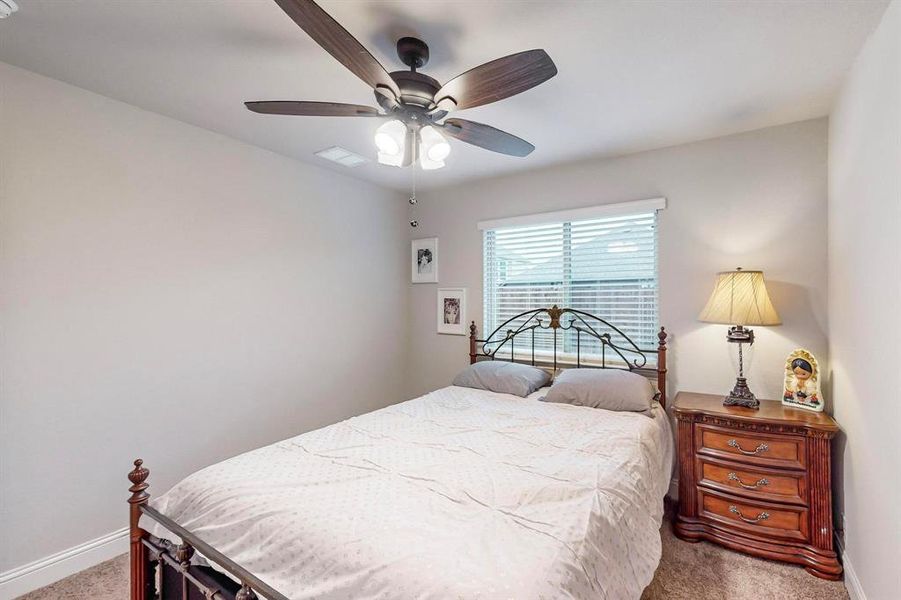 Bedroom featuring ceiling fan and carpet floors