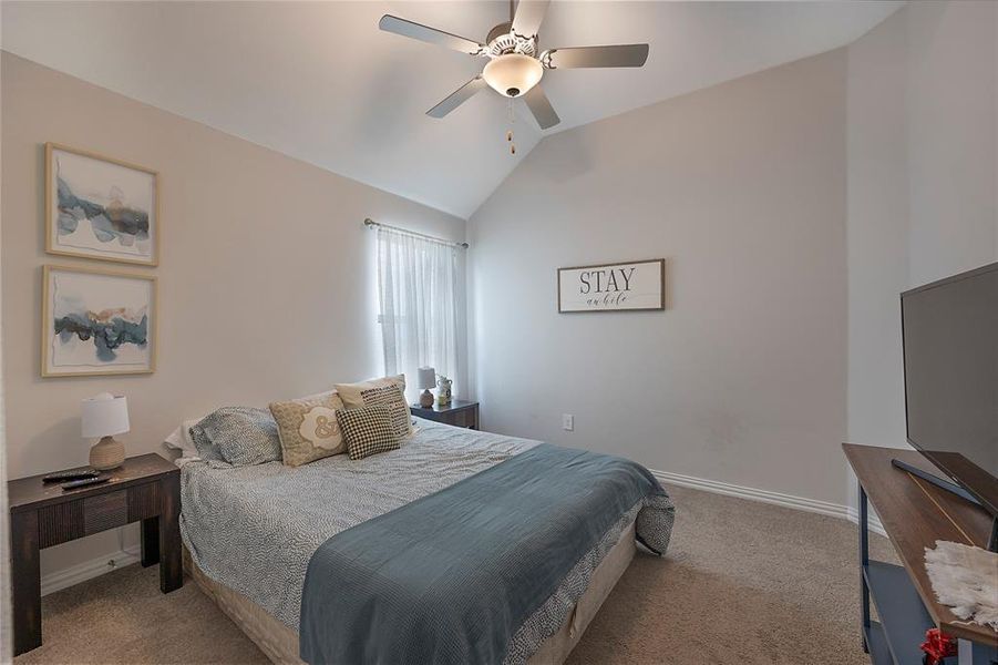 Bedroom with lofted ceiling, light colored carpet, and ceiling fan