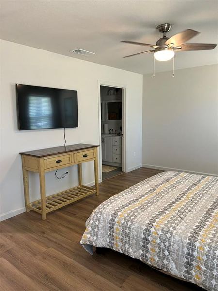 Bedroom with dark hardwood / wood-style floors and ceiling fan