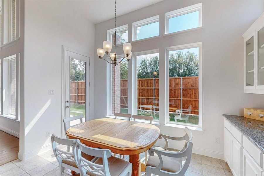 Tiled Breakfast nook with with chandelier and a wealth of natural light and large windows to provide an even more spacious environment.