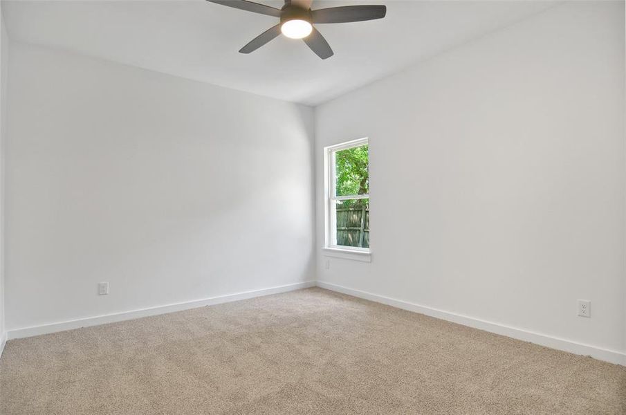 Carpeted empty room with ceiling fan