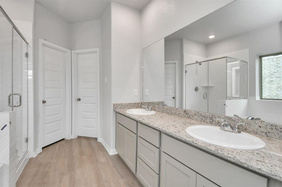 Additional view of primary bath equipped with double sinks and built in shelving.