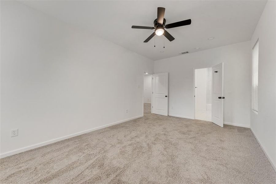 Unfurnished bedroom featuring light carpet and ceiling fan