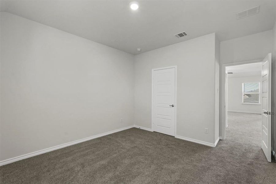 Unfurnished bedroom with dark carpet