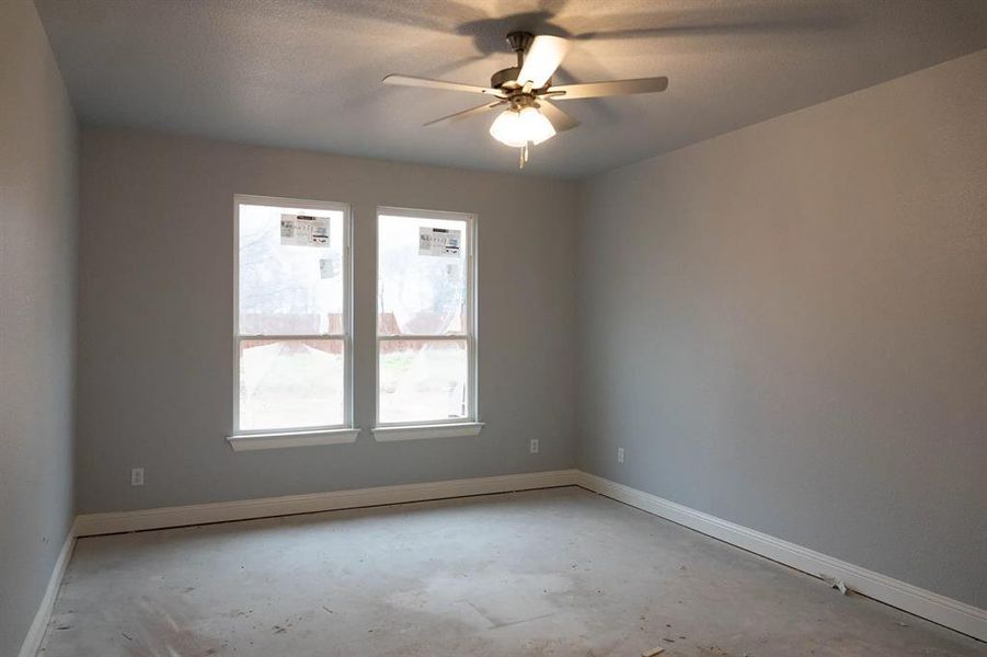 Spare room featuring concrete flooring and ceiling fan