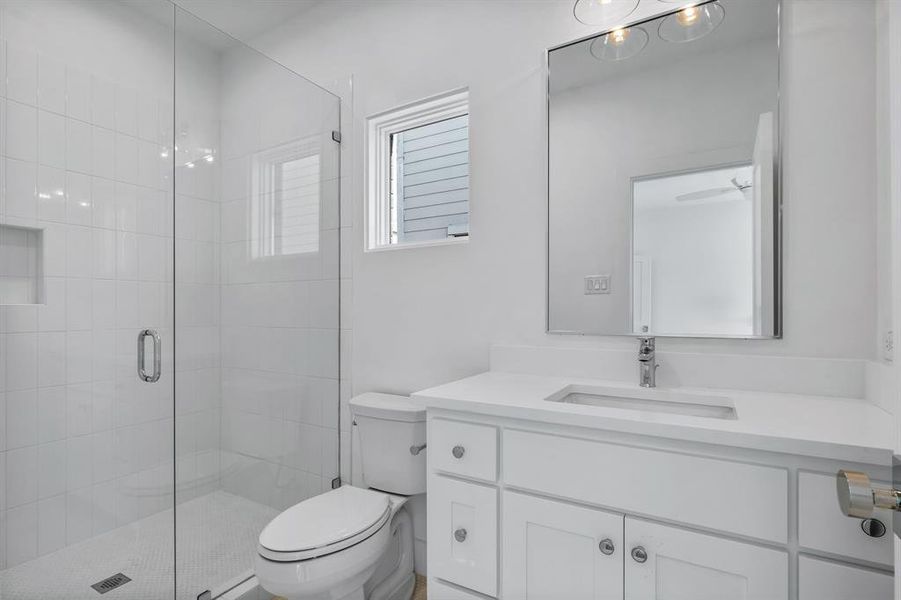 Bathroom featuring vanity, toilet, and walk in shower