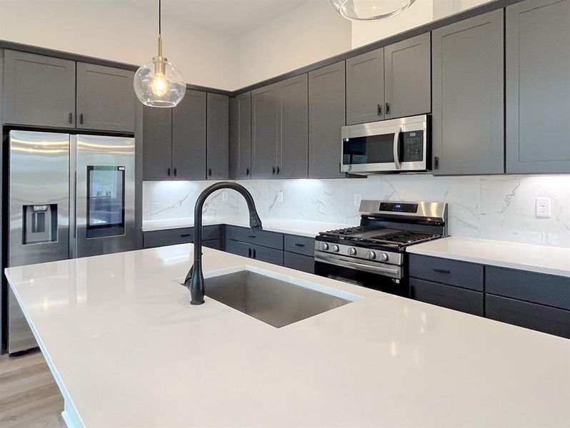 Modern Chef's Kitchen: Sleek charcoal cabinetry, pristine quartz countertops, and state-of-the-art stainless steel appliances.