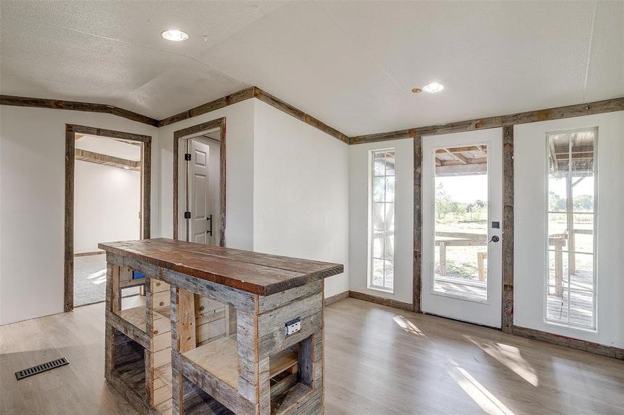 Dining space with light hardwood / wood-style floors and vaulted ceiling