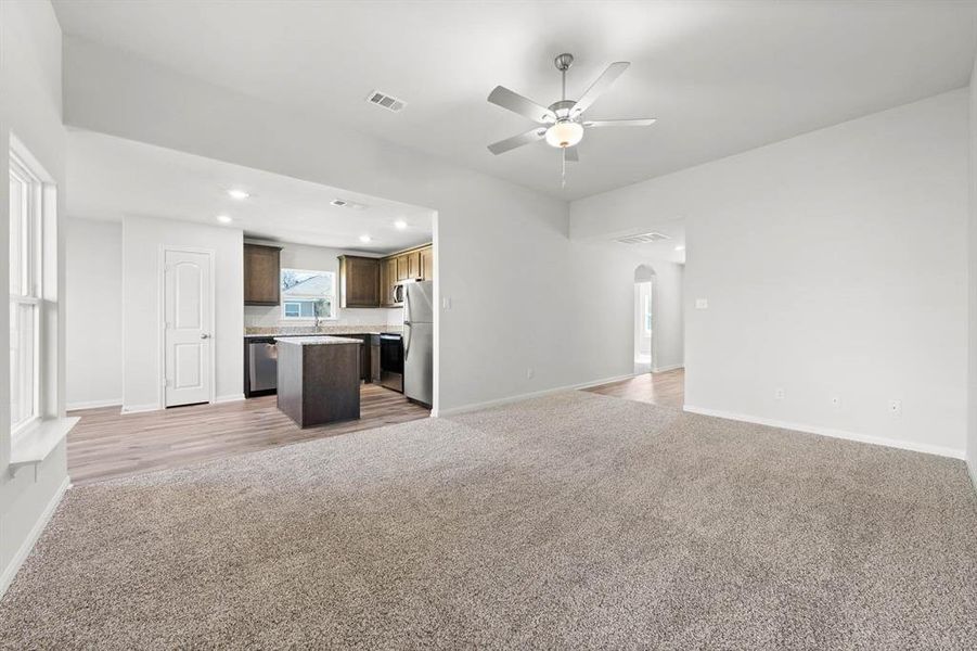 Unfurnished living room featuring ceiling fan, hardwood / wood-style flooring, and sink