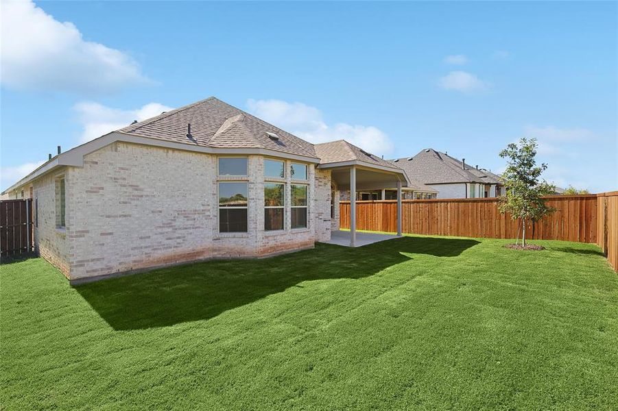 Rear view of house with a patio area and a lawn