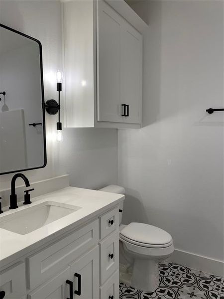 Bathroom featuring tile patterned floors, vanity, and toilet