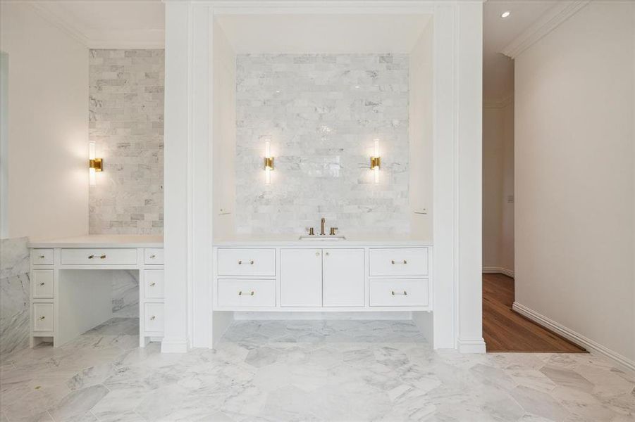 This stunning primary bathroom is elegantly swathed in marble, featuring an exquisite soaking tub that invites relaxation. A spacious walk-in shower and a thoughtfully designed vanity with knee space offer both luxury and practicality, all framed by stunning treetop views.