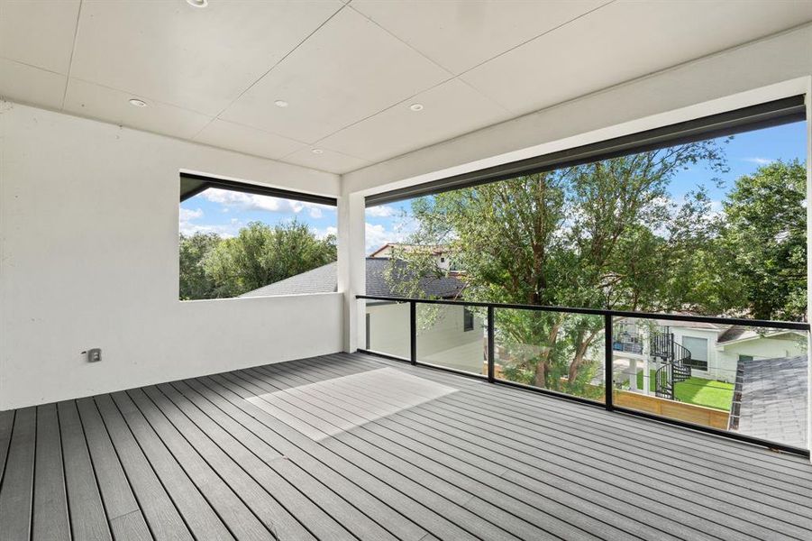 This second floor balcony features hardwood flooring and recessed lighting perfect for enjoying this serene private view.