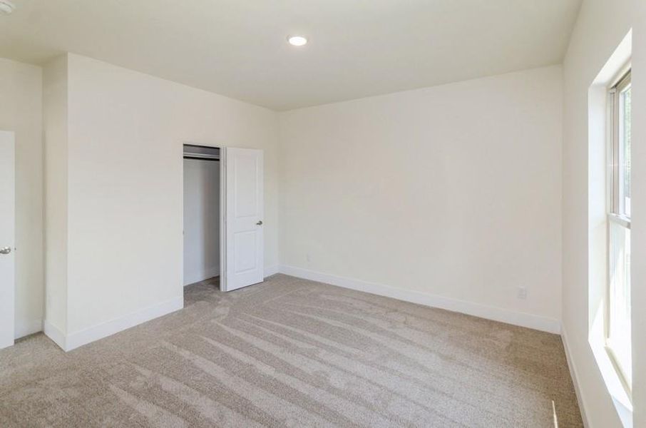 Unfurnished bedroom with light colored carpet