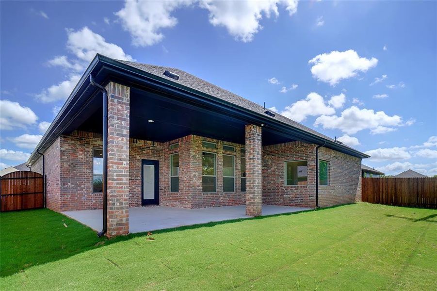 Rear view of house with a lawn and a patio area