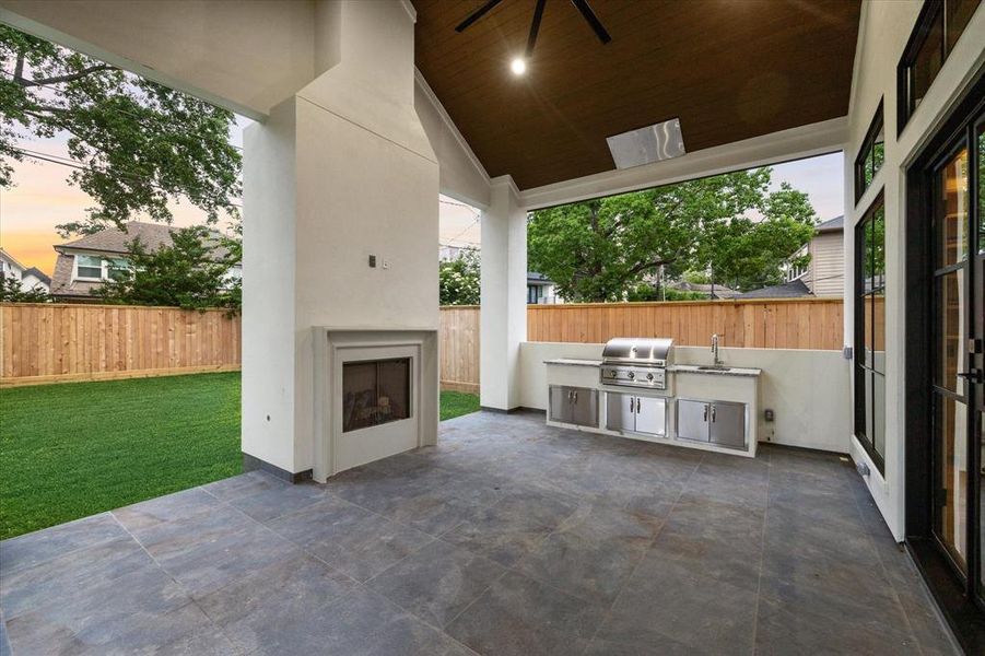 Hours will be spent in the covered patio featuring Pennsylvania blue porcelain tile, vaulted ceiling with large fan, stunning cast-stone fireplace and outdoor kitchen.