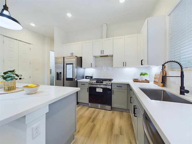 The kitchen offers quartz countertops, stainless steel appliances, recessed lighting, and shaker cabinets and hardware with under cabinet lighting.