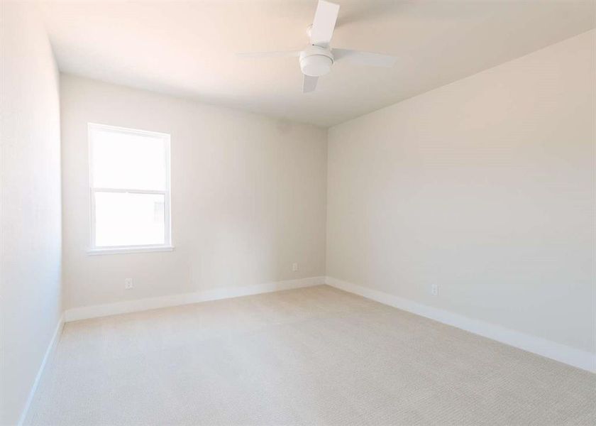 Empty room with light carpet and ceiling fan