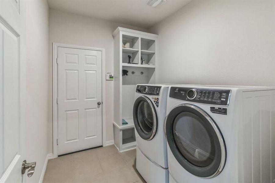 Laundry area featuring light tile patterned flooring and separate washer and dryer