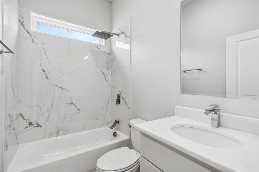 Full bathroom with vanity, toilet, and tiled shower / bath