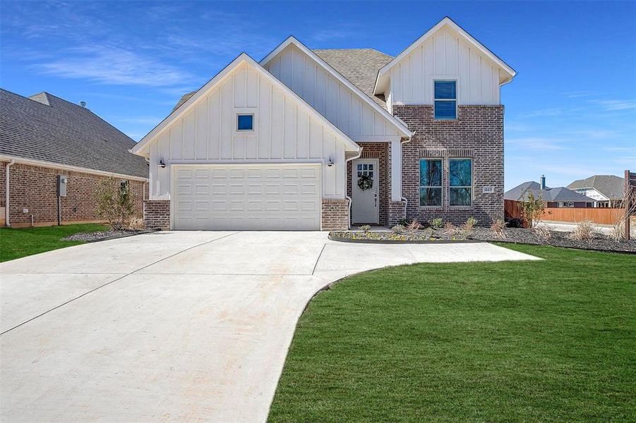 View of front facade with a front lawn and a garage