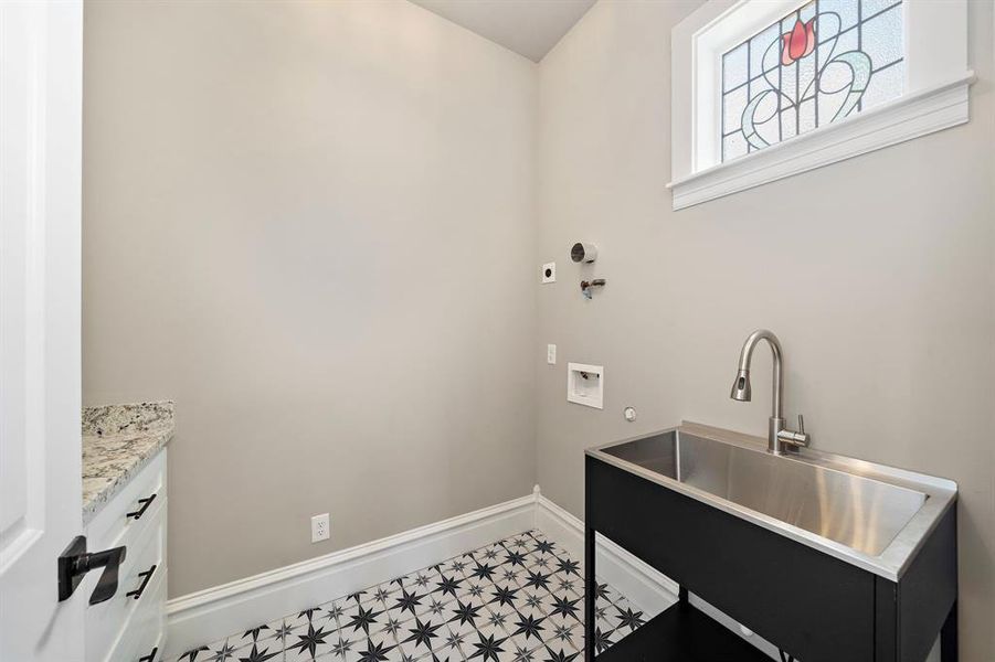 Second floor laundry with extra wide / deep stainless steel sink. Granite counters to folding or ironing. Stained glass in here, letting in natural light!