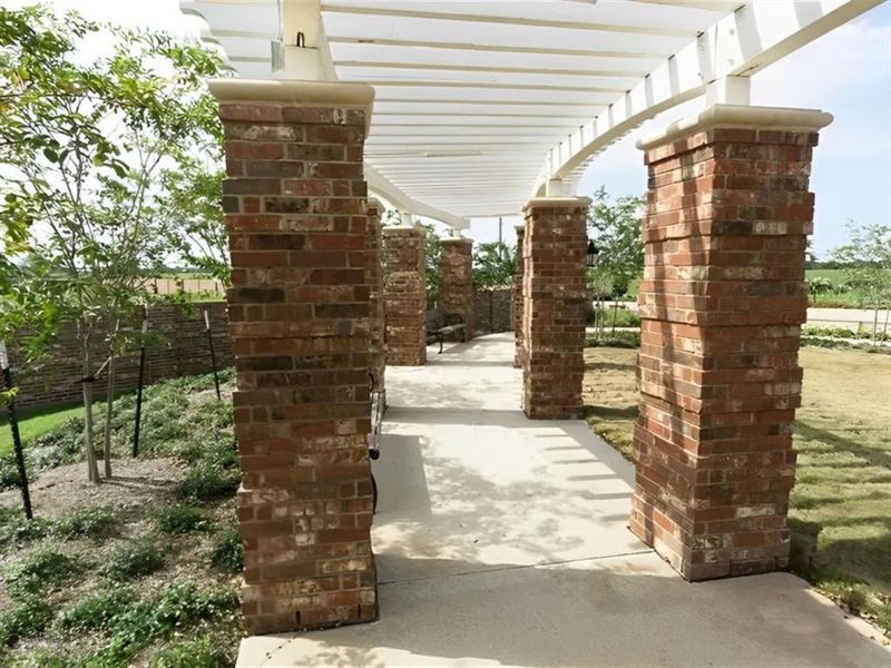 Unwind and relax in the tranquility of this white pergola with brick pillars.