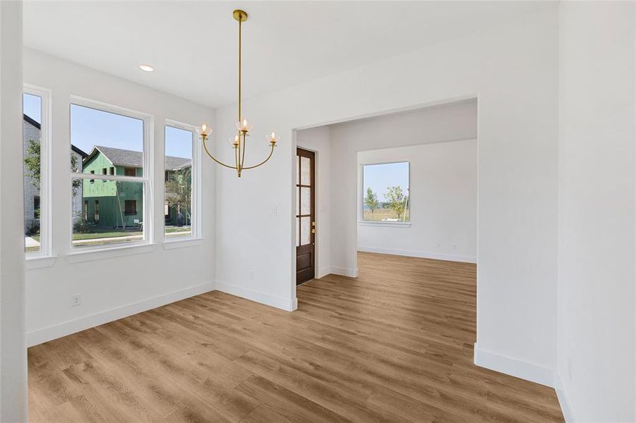 Unfurnished dining area featuring hardwood / wood-style flooring and an inviting chandelier