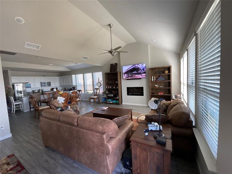 Living room featuring ceiling fan, lofted ceiling, and dark hardwood / wood-style flooring