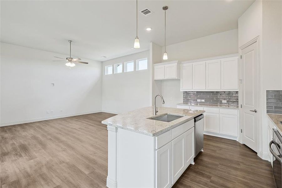 Kitchen featuring a center island with sink, white cabinetry, sink, and ceiling fan