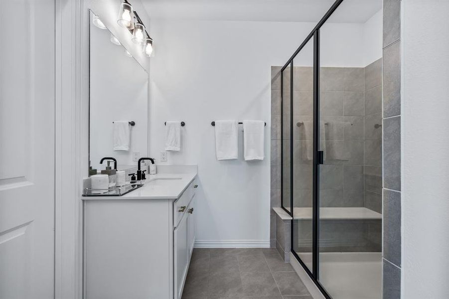 Bathroom featuring walk in shower, tile patterned floors, and vanity