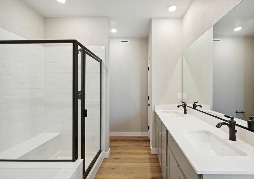 The master bathroom has a large vanity with his and hers sinks.