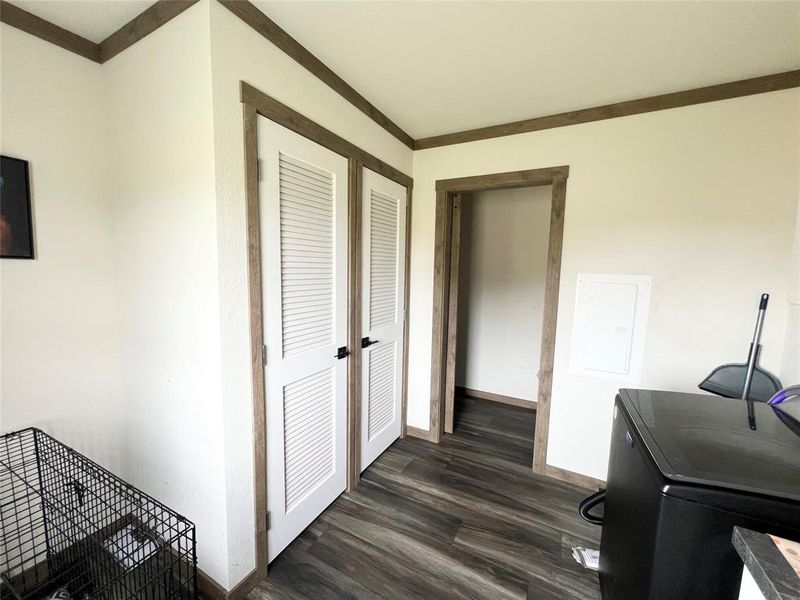 Home office featuring crown molding, washer / clothes dryer, and dark hardwood / wood-style flooring