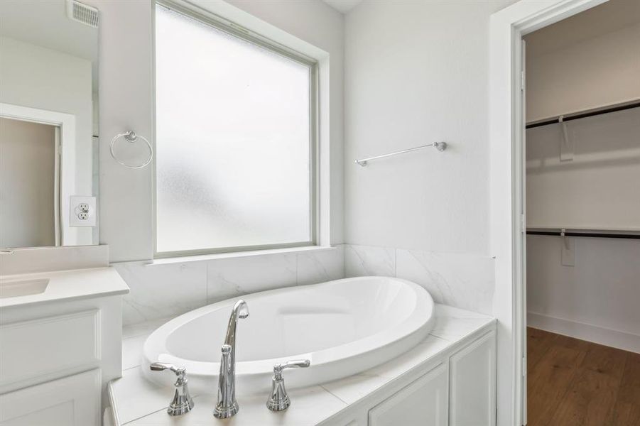 Bathroom with vanity, a tub, and plenty of natural light